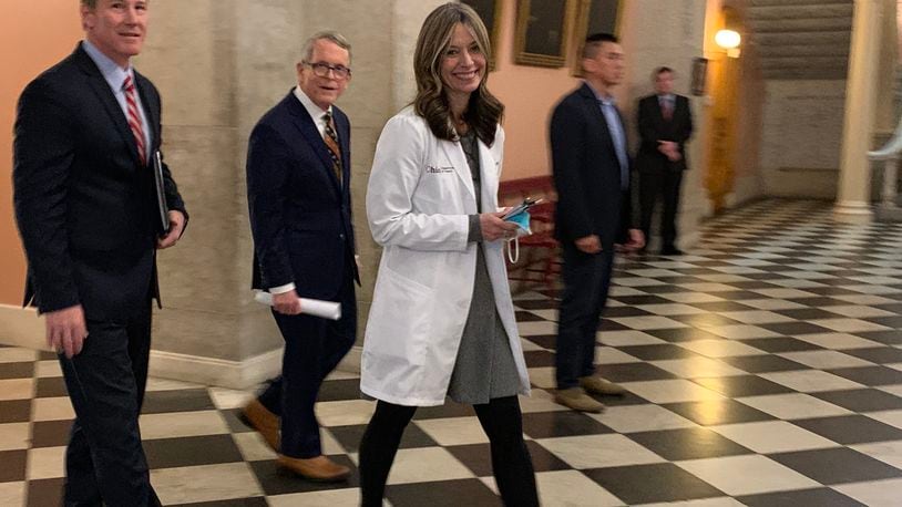 Ohio Gov. Mike DeWine (center) walks with Health Director Dr. Amy Acton (right) and Lt. Gov. Jon Husted (left) after Wednesday's press conference at the Statehouse. LAURA A. BISCHOFF/STAFF