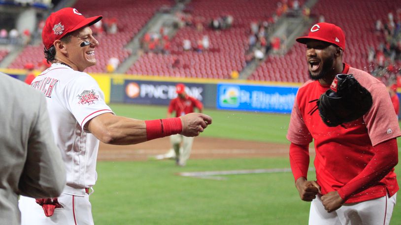 Derek Dietrich, left, reacts after Amir Garrett dumped a bucket of Powerade on him after a victory against the Pirates on Tuesday, May 28, 2019, at Great American Ball Park in Cincinnati. David Jablonski/Staff