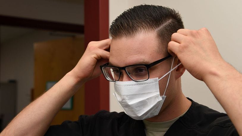Senior Airman Alexis Lopez, dental assistant with the 319th Medical Group, demonstrates proper sanitary procedure by putting on a face mask at the medical treatment facility at Grand Forks Air Force Base, N.D., Sept. 7, 2017. Lopez said in addition to personal sanitation, there are also multiple steps taken to ensure treatment rooms are sanitary and prepared for patient use. (U.S. Air Force photo/Airman 1st Class Elora J. Martinez)