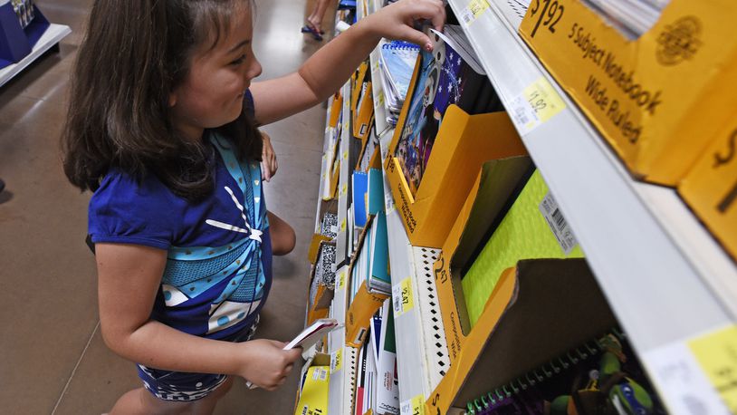 Gracie Reece, 7, shops for school supplies with her mom and grandma Thursday, July 30 at Walmart on Cincinnati-Dayton Road in West Chester Twp. NICK GRAHAM/STAFF