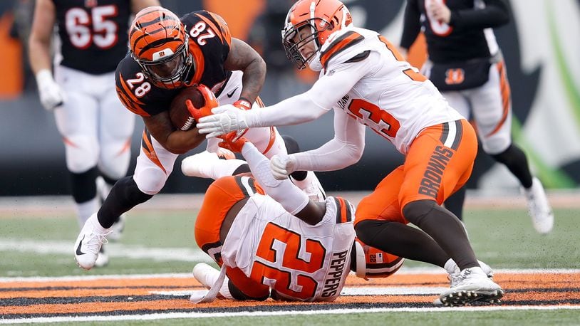 CINCINNATI, OH - NOVEMBER 25: Joe Mixon #28 of the Cincinnati Bengals is tackled by Jabrill Peppers #22 of the Cleveland Browns and Joe Schobert #53 during the fourth quarter at Paul Brown Stadium on November 25, 2018 in Cincinnati, Ohio. Cleveland defeated Cincinnati 35-20. (Photo by Joe Robbins/Getty Images)