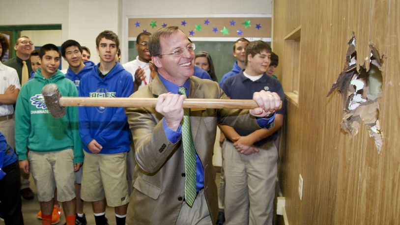 John Marshall, principal of Chaminade Julienne Catholic High School, drives a sledge hammer into an interior wall Wednesday after announcing plans to start construction soon on a multimillion dollar renovation that will turn some existing classrooms into a new STEMM Center that will open next school year.