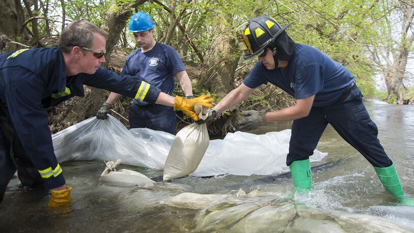 Responders with the 788th Civil Engineering Fire Department use sandbags and plastic to build a dam May 2 in Hebble Creek onWright-Patterson Air Force Base. The project was part of a base exercise used to train personnel in emergency response. (U.S. Air Force photos/R.J. Oriez)
