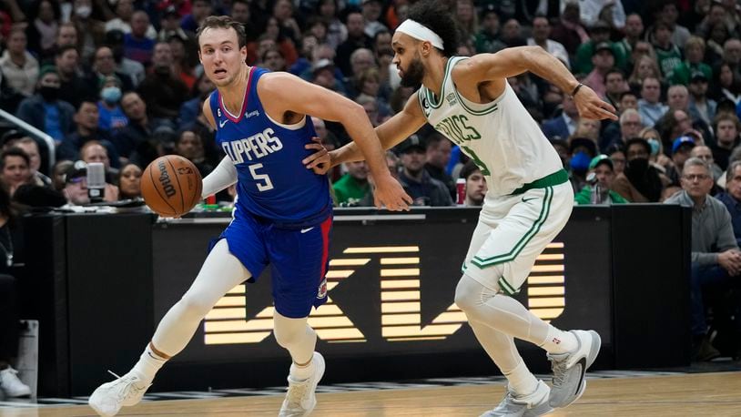 Los Angeles Clippers' Luke Kennard (5) drives past Boston Celtics' Derrick White during first half of an NBA basketball game Monday, Dec. 12, 2022, in Los Angeles. (AP Photo/Jae C. Hong)