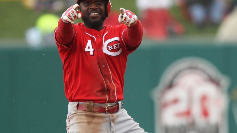 The Reds’ Brandon Phillips points to a teammate at third base after an RBI hit in the third inning against the Pirates in an exhibition game at Victory Field in Indianapolis on Saturday, April 2, 2016. David Jablonski/Staff