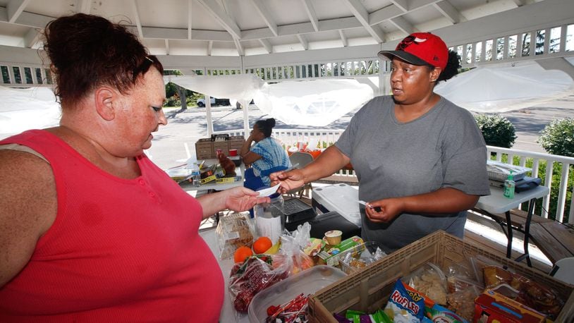 Neah Rainey, right, has been handing out home-cooked meals and personal items to tornado survivors. She gave help to hundreds a day right after the storm hit Memorial Day. And just about every day she can still be found at the gazebo at Shiloh Church with her mother, Zola Williams, helping out families, including Cassie Pepper, who stopped by for help recently. CHRIS STEWART / STAFF