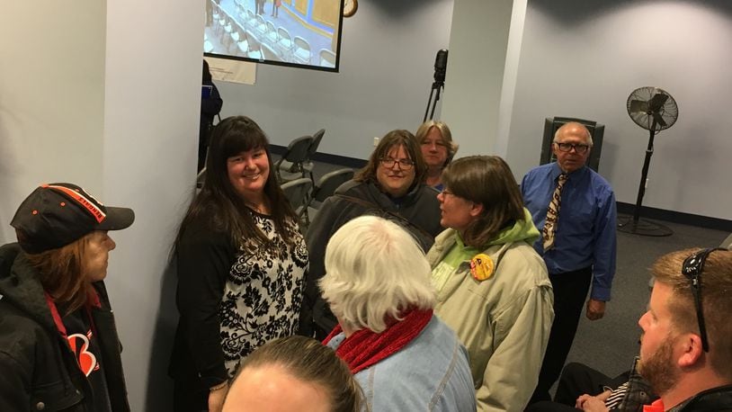 Jennifer Dearwester (left, facing camera), principal of Ruskin PreK-6 School, is surrounded by colleagues and supporters at the April 17 Dayton school board meeting. Superintendent Elizabeth Lolli recommended not renewing her contract. JEREMY P. KELLEY / STAFF