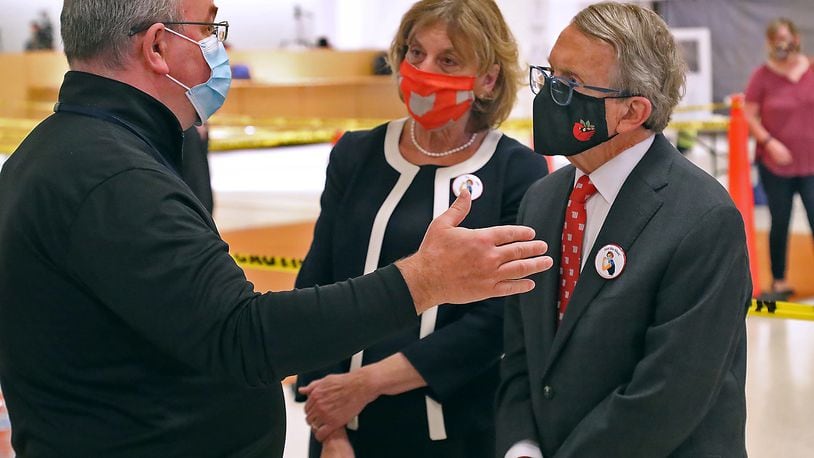 Clark County Health Commissioner Charles Patterson talks with Governor Mike DeWine and his wife, Fran, during a tour of the Clark County COVID vaccine distribution center at the Upper Valley Mall Thursday. BILL LACKEY/STAFF
