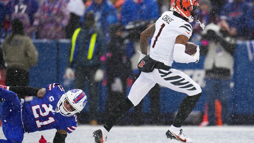 Cincinnati Bengals wide receiver Ja'Marr Chase (1) runs in a touchdown after catching a pass against Buffalo Bills safety Jordan Poyer (21) during the first quarter of an NFL division round football game, Sunday, Jan. 22, 2023, in Orchard Park, N.Y. (AP Photo/Seth Wenig)