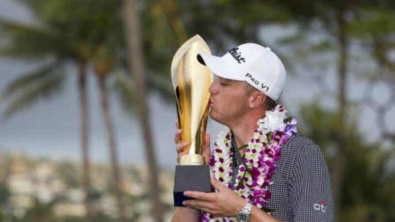 Justin Thomas kisses the trophy after winning the Sony Open golf tournament Sunday, Jan. 15, 2017, in Honolulu. Challenged only by the record book, Thomas won the Sony Open on Sunday with the lowest 72-hole score in PGA Tour history. (AP Photo/Marco Garcia)