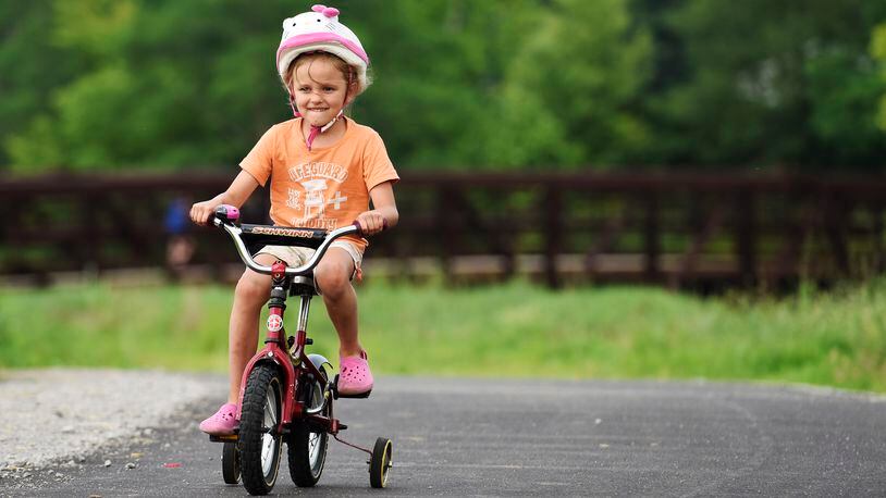 Madelyn Hartkemeyer, 5, rides her bike on the Great Miami River Recreation Trail after a dedication hosted by the Hamilton Community Foundation Wednesday, July 1, 2015, in Fairfield Twp. Monroe is grants to be used in construction of its portion of the trail. NICK GRAHAM/STAFF