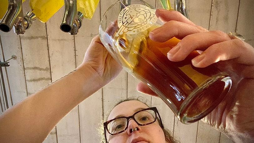 Yellow Springs Brewery bartender, Juliana Crass, pours a cold beer from the tap Thursday, April 20, 2023. The business is celebrating its 10th year anniversary. MARSHALL GORBY \STAFF