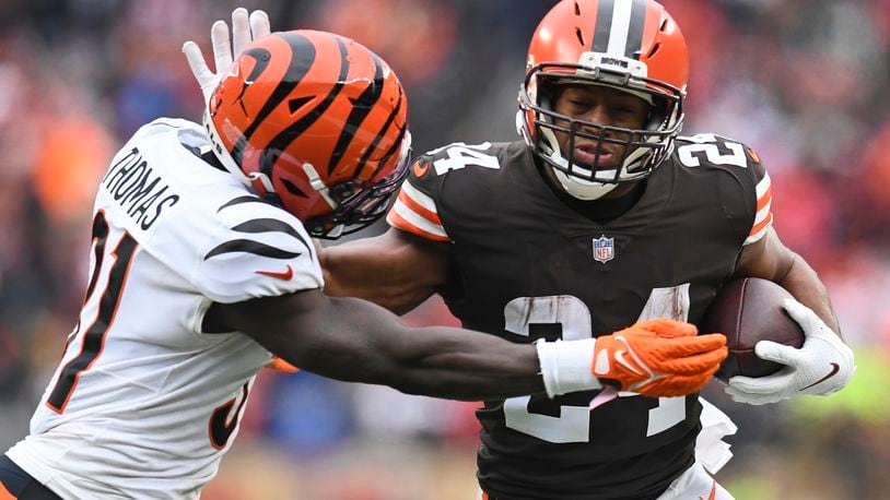 Cleveland Browns running back Nick Chubb (24) tries to break a tackle from Cincinnati Bengals defensive back Michael Thomas (31) during the second half of an NFL football game, Sunday, Jan. 9, 2022, in Cleveland. (AP Photo/Nick Cammett)