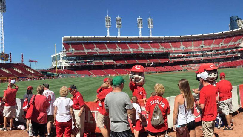 Reds fans wait to take photos with players on Sunday, July 2, 2017, at Great American Ball Park before a game against the Cubs in Cincinnati.