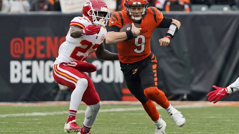 Cincinnati Bengals quarterback Joe Burrow (9) scrambles against Kansas City Chiefs cornerback Rashad Fenton (27) during the first half of an NFL football game, Sunday, Jan. 2, 2022, in Cincinnati. (AP Photo/Jeff Dean)