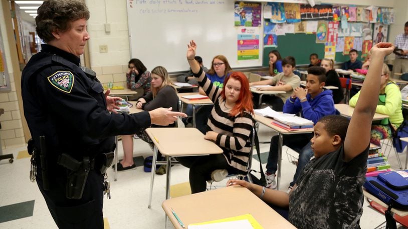 Kettering Police school resource officer Carla Sucher talks with seventh-grade students in a health class at Van Buren Middle School about alcohol abuse. Many schools rely on the presence of SROs to boost security. LISA POWELL / STAFF