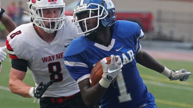 Dunbar's Darian Leslie tries to avoid Wayne linebacker Adam Trick during on Friday, Aug. 20, 2021. Trick on Wednesday signed to play collegiately at Miami. BILL LACKEY/STAFF