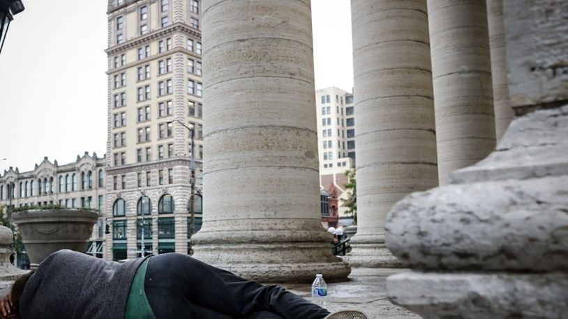 A homeless man sleeps on the Main Street side of the Courthouse Square steps Wednesday September 27, 2023. JIM NOELKER/STAFF