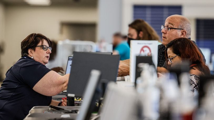 Travelers at the Dayton International Airport check in at a ticket counter before traveling Friday July 15, 2022. JIM NOELKER/STAFF