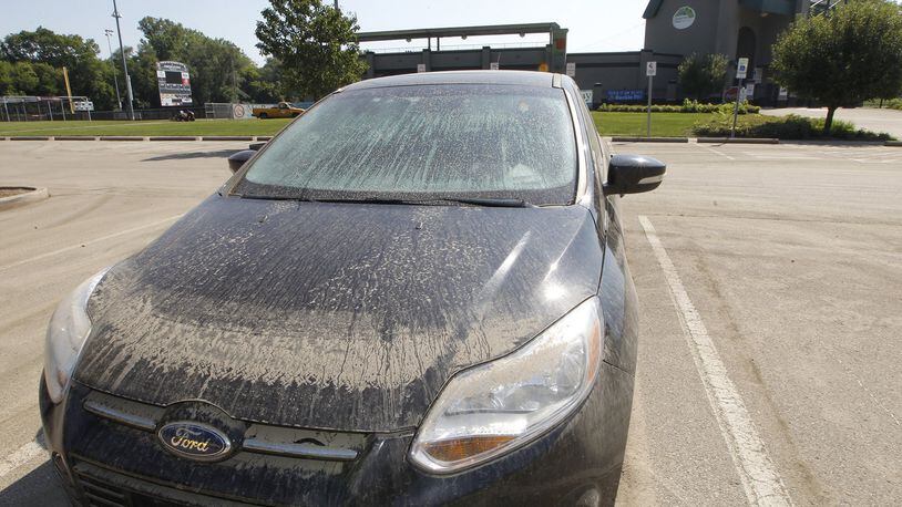 A car still sits in the parking lot of Carlton Davidson Stadium Wednesday, covered with mud and full of water from the flooding last week. Bill Lackey/Staff