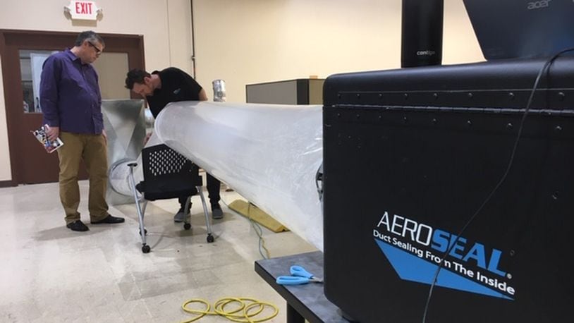 From left, Kevin Dugan, marketing director for Miamisburg company Aeroseal, and Matt Damron, Aeroseal strategic account manager, run a test in the duct-sealing technology company’s demonstration area. THOMAS GNAU/STAFF