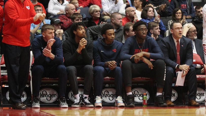 Dayton players (left to right) Chase Johnson, Ibi Watson, Rodney Chatman and Jordy Tshimanga sit on the bench, along with coach Andy Farrell, far right, against Massachusetts on Sunday, Jan. 13, 2019, at UD Arena. David Jablonski/Staff