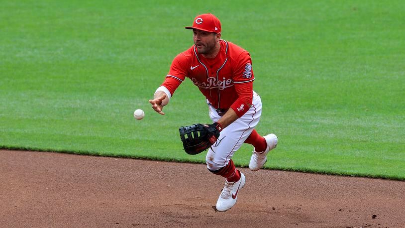 Cincinnati Reds' Joey Votto fields the ball and throws to first base during the first inning of a baseball game against the Chicago White Sox in Cincinnati, Wednesday, May 5, 2021. (AP Photo/Aaron Doster)