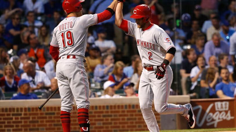 Cincinnati Reds’ Zack Cozart (2) celebrates his home run off Chicago Cubs starting pitcher Kyle Hendricks with Joey Votto during the third inning of a baseball game Wednesday, May 17, 2017, in Chicago. (AP Photo/Charles Rex Arbogast)