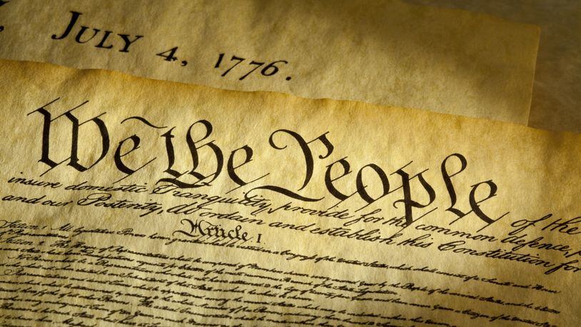 We the People are the opening words of the preamble to the Constitution of the USA. The document underneath is a copy of the Declaration of Independence with the date, July 4, 1776 showing.