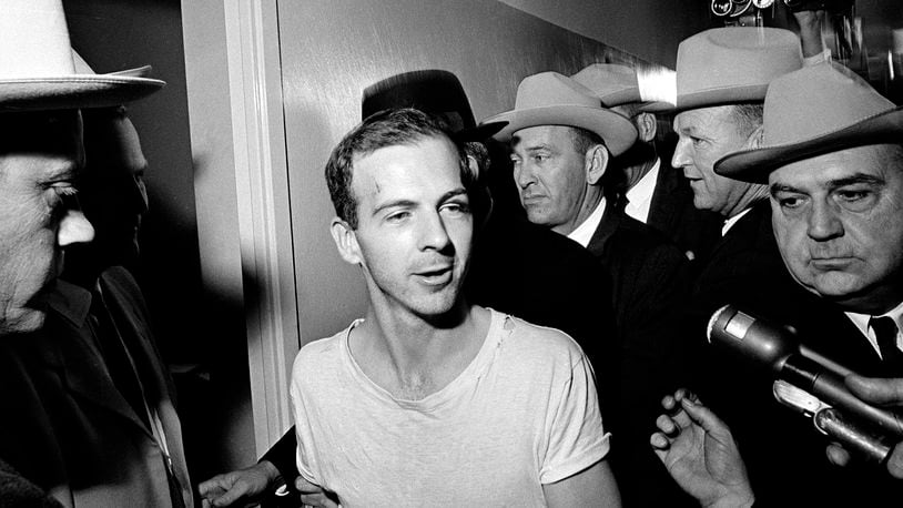 FILE — Surrounded by detectives, Lee Harvey Oswald talks to the media as he is led down a corridor of the Dallas police station, Nov. 23, 1963, for another round of questioning in connection with the assassination of U.S. President John F. Kennedy. The life insurance policy on the man who assassinated Kennedy paid out less than $900 to his mother, but the death claim she filed to get that sum has sold at auction for almost $80,000. The original Notice of Insurance Claim for Lee Harvey Oswald sold for $79,436 on Wednesday, April 13, 2022, Boston-based RR Auction said in a statement. (AP Photo/File)