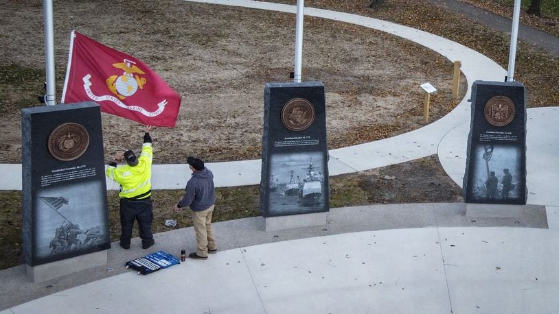 Workers add finishing touches on the new veteran's memorial being unveiled on Saturday Nov. 6, 2021 at Thomas Cloud Park in Huber Heights. JIM NOELKER/STAFF