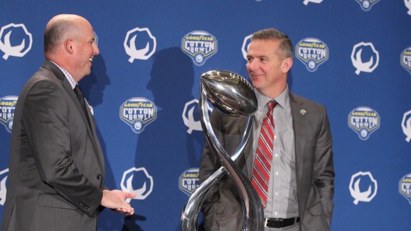 Southern California coach Clay Helton and Ohio State coach Urban Meyer pose for a photo with the Cotton Bowl trophy on Thursday, Dec. 28, 2017, at the Omni Dallas Hotel in Dallas, Texas. David Jablonski/Staff