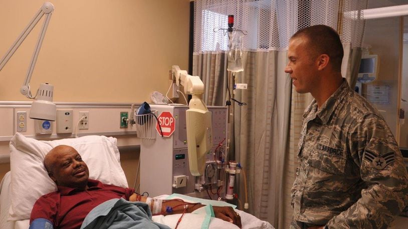 Senior Airman Jason Scoles, a dialysis technician with the 88th Medical Group, checks on his patient John Pennix as Pennix is receiving his dialysis treatment at the Wright-Patterson Medical Center. Patients go on dialysis when the kidneys are no longer able to filter and clean blood on its own. (U.S. Air Force photo/Stacey Geiger)