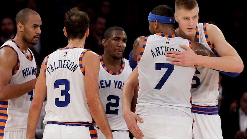 New York Knicks forward Carmelo Anthony (7) hugs New York Knicks forward Kristaps Porzingis (6) as they huddle with guard Arron Afflalo (4), guard Jose Calderon (3) and guard Langston Galloway (2) during the fourth quarter of an NBA basketball game against the Charlotte Hornets, Tuesday, Nov. 17, 2015, in New York. (AP Photo/Julie Jacobson)