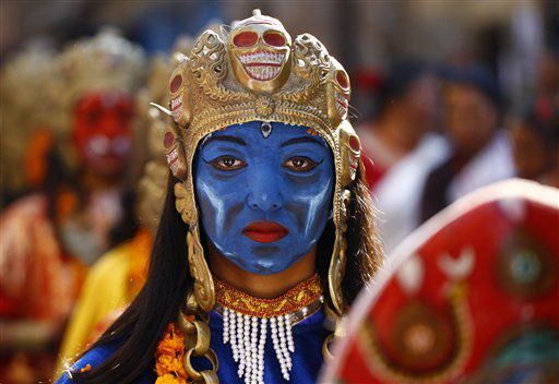A Newar community girl dressed as a deity watches as she participates in a parade marking Yomari Puni festival in Katmandu, Nepal.
