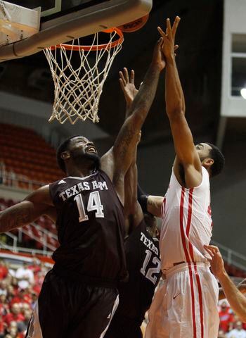 Dayton's Devon Scott, right, tips in a shot over Texas A&amp;M's Kourtney Roberson with 1.2 seconds left in the first round of the Puerto Rico Tip-Off on Thursday, Nov. 20, 2014, at Coliseo Roberto Clemente in San Juan. David Jablonski/Staff