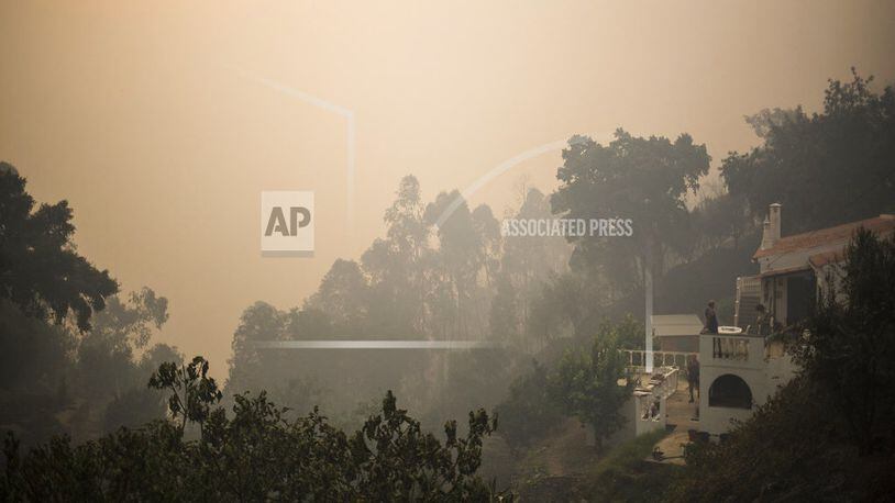 Residents return to their homes in the village of Monchique, in southern Portugal's Algarve region, Monday, Aug. 6 2018. Emergency services in Portugal say they are still fighting a major wildfire on the south coast that threatened to engulf a hillside town overnight. (AP Photo/Javier Fergo)