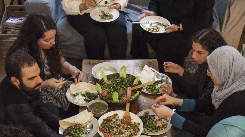 Guests at a dinner cooked by Syrian refugee women at the home of Anna Gyulai Gaal in Berlin, April 23, 2016. Gaal organizes dinners cooked by refugees for paying diners, and then donates the money to the refugees, who are not allowed to work in Germany. (Andreas Meichsner/The New York Times)
