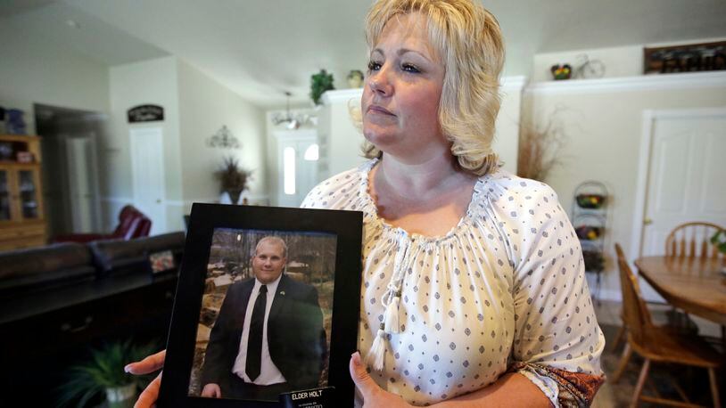 In this July 13, 2016 file photo, Laurie Holt holds a photograph of her son Josh Holt at her home, in Riverton, Utah.  Josh Holt  has been released from a jail in Venezuela after spending nearly two years behind bars on weapons charges.