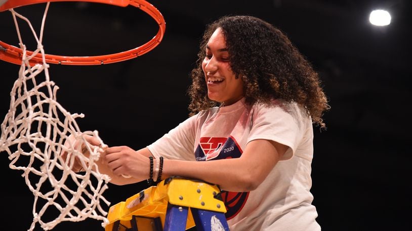 Dayton's Destiny Bohanon cuts down the net on March 8, 2020, after the Atlantic 10 tournament championship game at UD Arena. Photo by Erik Schelkun