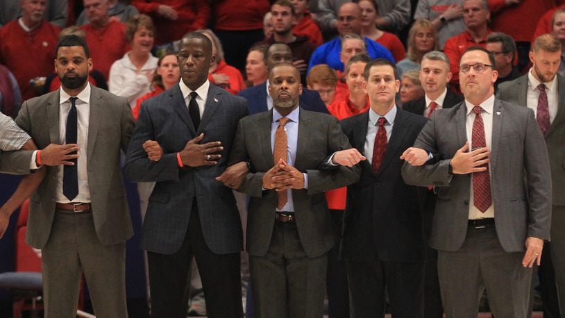 Dayton coaches stand for the national anthem before a game against Grambling State on Monday, Dec. 23, 2019, at UD Arena. From left to right are Ricardo Greer, Anthony Grant, Anthony Solomon, Darren Hertz and Andy Farrell. David Jablonski/Staff