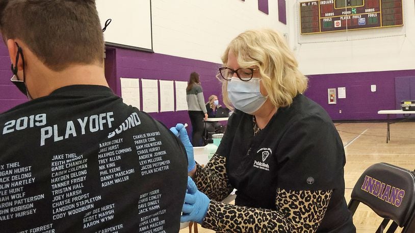 Hope Stickley, a nurse from the Champaign County Health Department, gives a student the COVID vaccine during a COVID clinic in one of  Mechanicsburg High School's gymnasiums. BILL LACKEY/STAFF