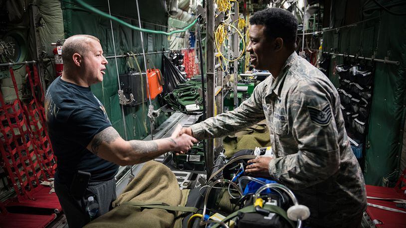 Retired Marine Corps Staff Sgt. Daniel Gilyeat, who lost his left leg in an explosion in July 2005 when his up-armored Humvee ran over a double-stacked anti-tank mine in Iraq, greets Tech. Sgt. Donald Ennis Jr., NCOIC of the Aeromedical Evacuation Course at the United States Air Force School of Aerospace Medicine. Ennis provided a coin to Gilyeat on behalf of the En Route Care Training Department as they toured one of the C-130 trainers in USAFSAM’s High Bay. Gilyeat was visiting USAFSAM to speak to students at the Aerospace Medicine Primary course March 4. (U.S. Air Force photo/Richard Eldridge)
