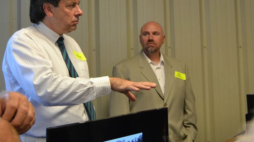 GP Caminiti (left), of Mitsubishi Electric Solar Innovations Division, and Ray Davis, president of OGW Energy Resources of Tipp City, talk to those touring the Shelby County Recycling Center to see technological improvements including a solar array system. CONTRIBUTED