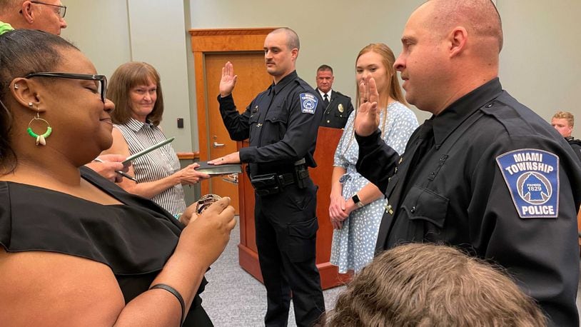 Miami Twp. Police Department staffing grew to 34 policer officers with the swearing in of two new officers Jason McIntosh (center) and Christopher Renkel (right) during a Miami Twp. Board of Trustees meeting Tuesday June 6, 2023. The two men were sworn in by Miami Twp. Fiscal Officer Greg Clingerman. CONTRIBUTED