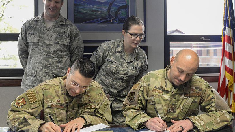 Col. Thomas Sherman, 88th Air Base Wing commander, and Chief Master Sgt. Stephen Arbona, 88th ABW command chief, sign their pledge forms for the Air Force Assistance Fund as Maj. Todd Brackett and Master Sgt. Anna Garrett, installation project officers for the 2019 AFAF fund, watch inside Sherman’s office at Wright-Patterson Air Force Base April 23. The fund is made up of four charitable organizations that provide support in an emergency, with educational needs or a secure retirement home for widows or widowers of Air Force members in need of financial assistance. (U.S. Air Force photo/Wesley Farnsworth)