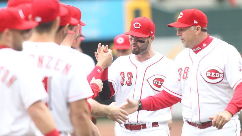 Reds outfielder Jesse Winker (33) and manager Bryan Price are introduced prior to Friday’s Opening Day game vs. the Nationals at Great American Ball Park. David Jablonski/STAFF