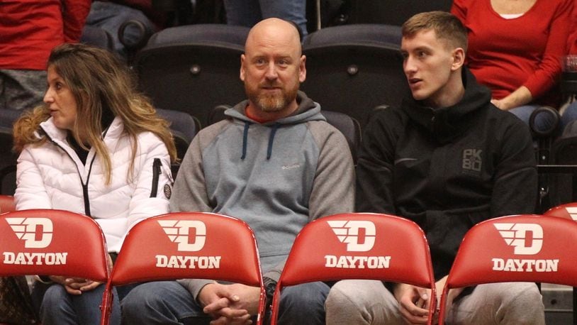 Chase Johnson, right, sits behind the Dayton bench during a game against Georgia Southern on Dec. 29, 2018, at UD Arena.