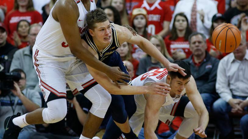 Michigan’s Moritz Wagner, center, passes the ball as Ohio State’s Kaleb Wesson, left, and Kyle Young defend during the first half of an NCAA college basketball game Monday, Dec. 4, 2017, in Columbus, Ohio. (AP Photo/Jay LaPrete)