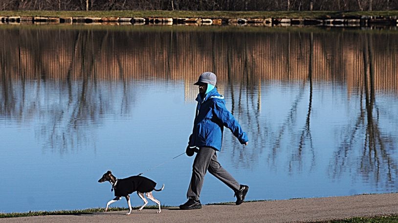 Sue Tackett walks her dog, Hobbs, around Delco Park in Kettering on a February morning. MARSHALL GORBY / STAFF
